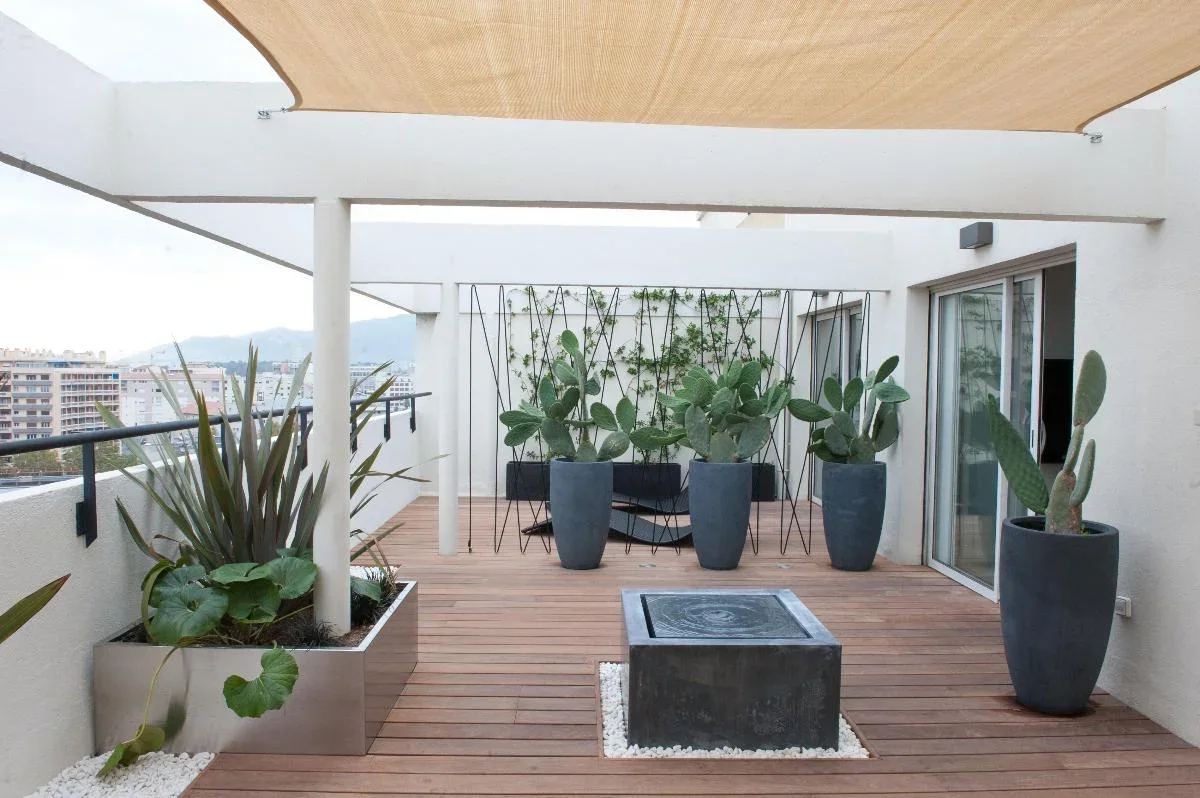 Un balcon avec terrasse bois et plantes en pots